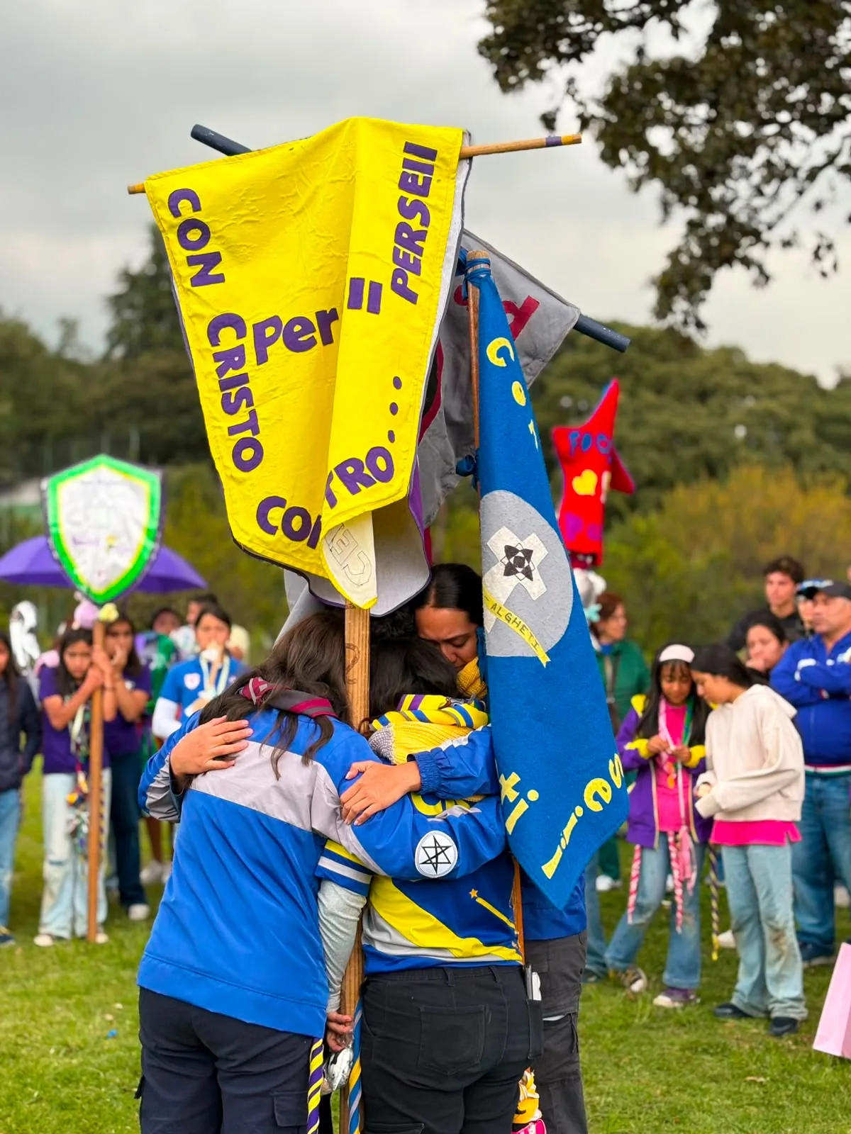 Integrantes del grupo abrazados junto a sus banderines